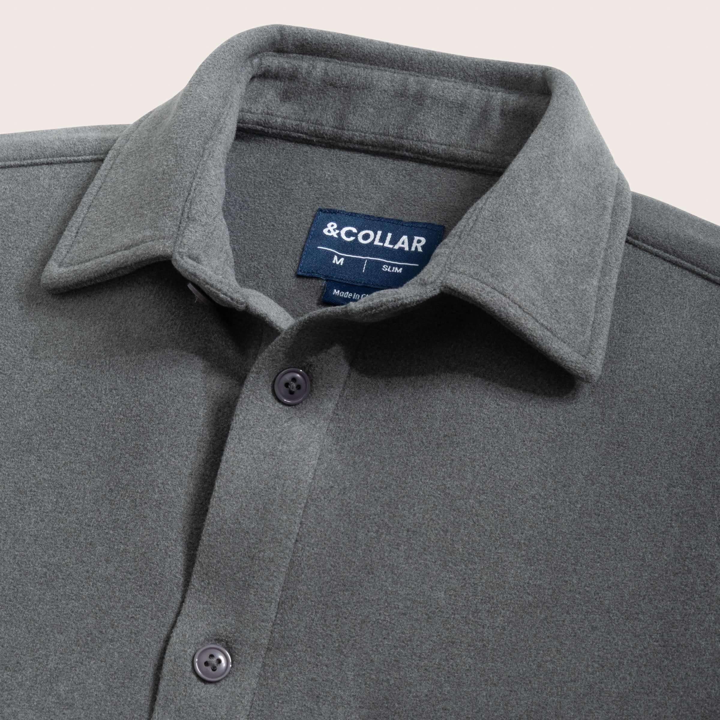 Charcoal gray button-up flannel shirt with collar and &Collar label on a beige background