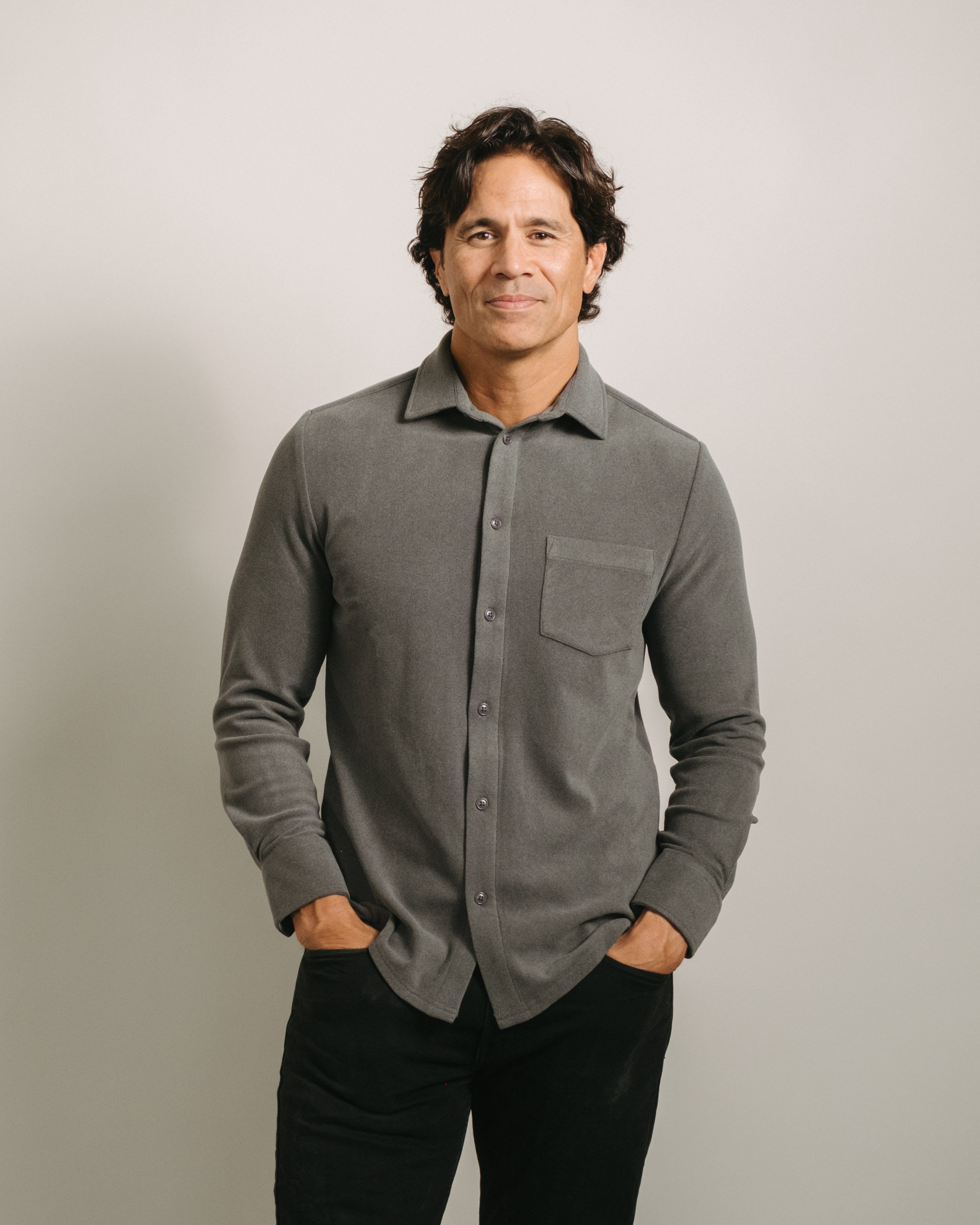 Man wearing a charcoal gray button-up flannel shirt against a plain background. Buttons match the shirt color.