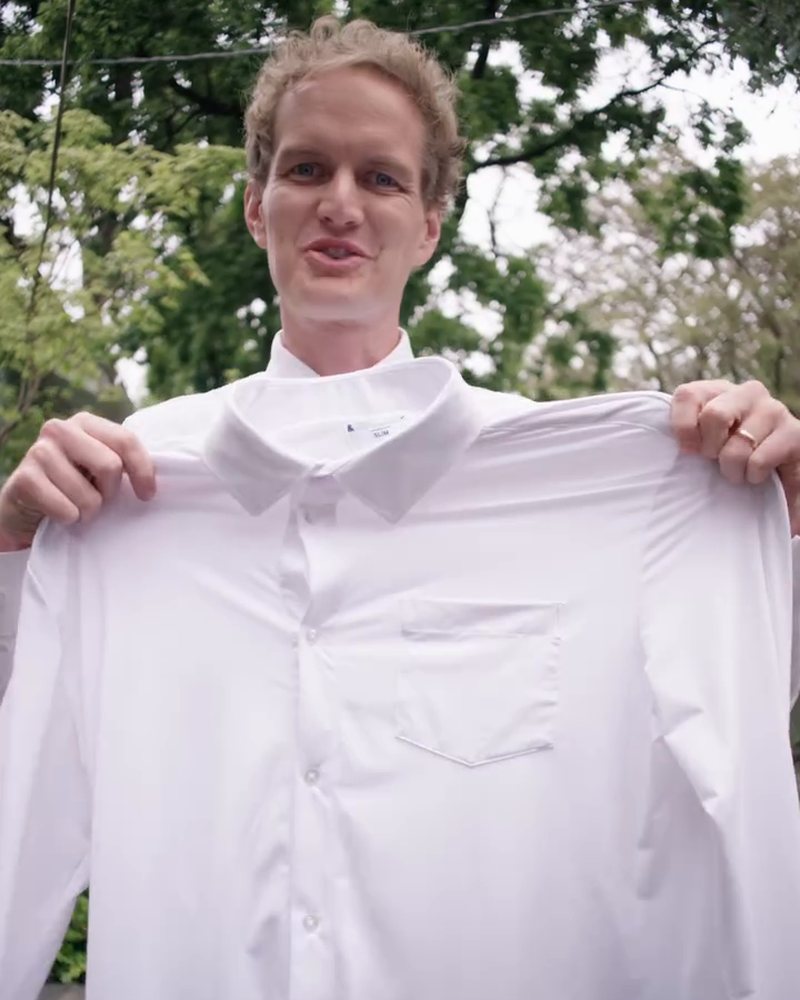 Ben Perkins holding up a white &Collar shirt