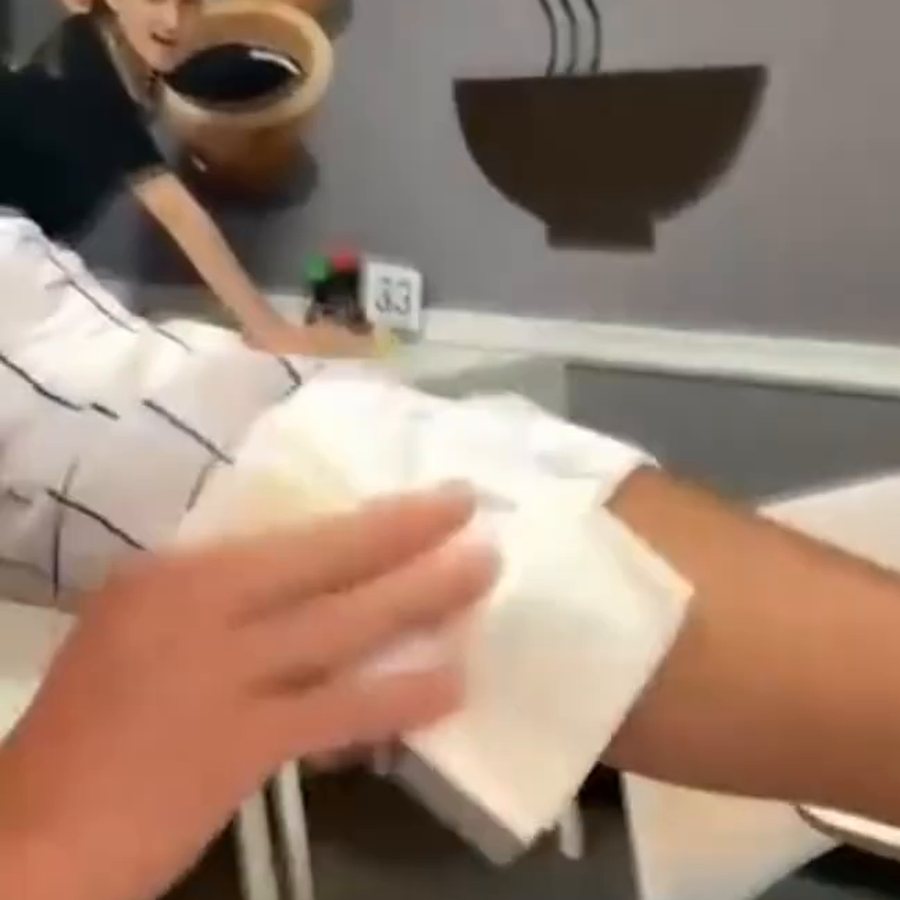 A napkin blotting a spill off a white shirt
