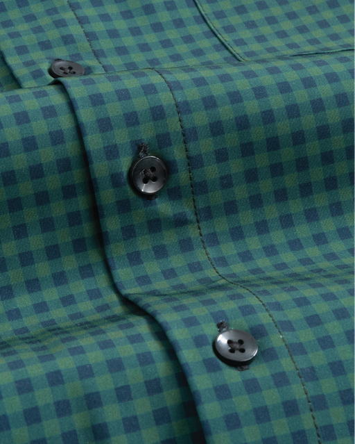 Close up of forest green and navy gingham shirt. Black buttons. 