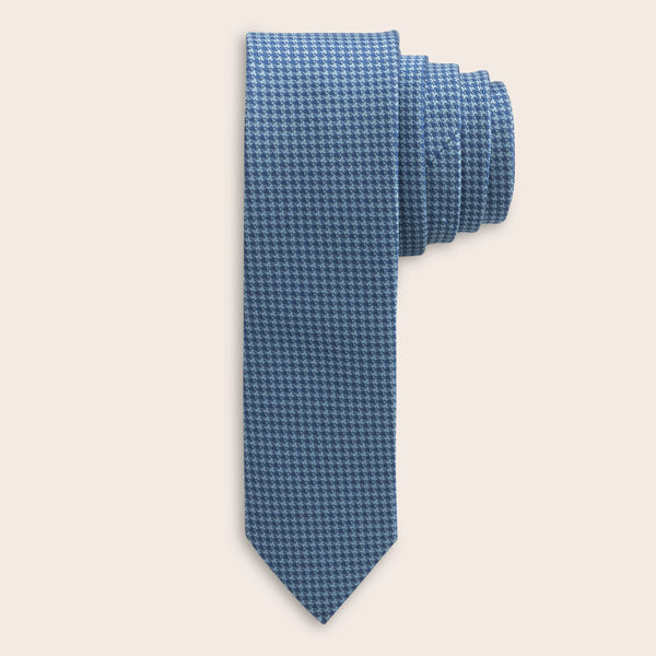 Blue houndstooth patterned tie on a light beige background