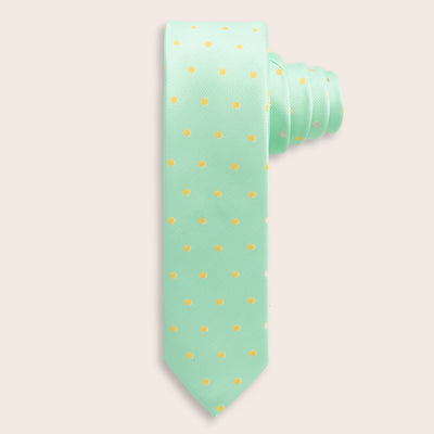 Mint green tie with yellow polka dots on a beige background