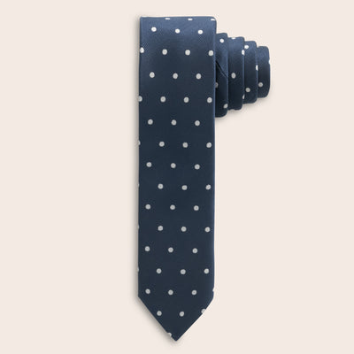 Navy blue tie with white polka dots on a beige background