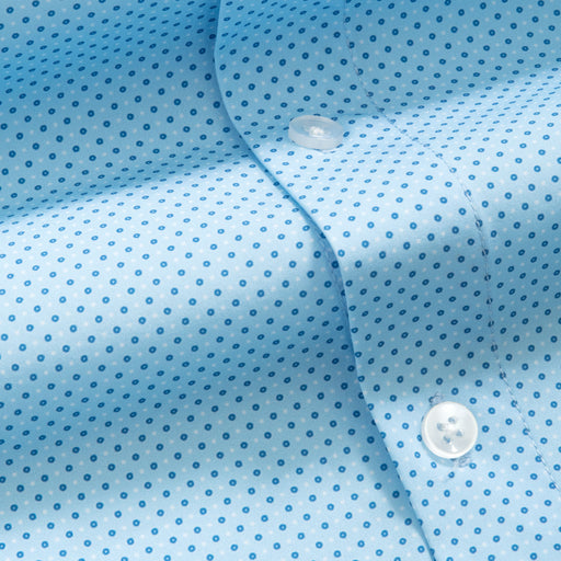 Close-up of a light blue shirt with small blue dots and a button.