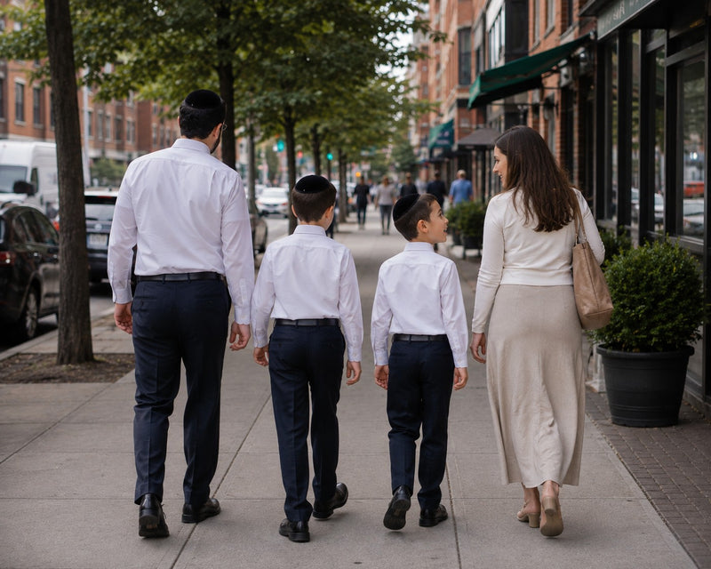 A father and his sons in white shirts walking to shul