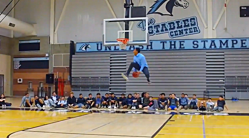 A teacher in a dress shirt dunking at a school assembly