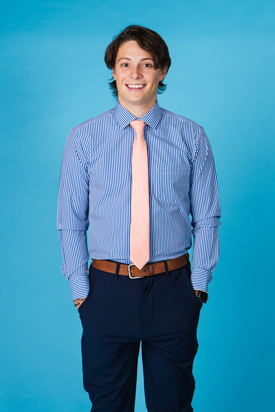 Salmon tie with blue paisley icons on a blue and white striped shirt.