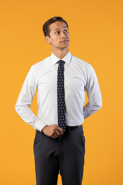 Navy blue tie with white circular pattern on a white shirt