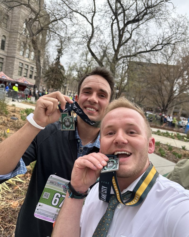 Two customers with race medals, in dress shirts and ties