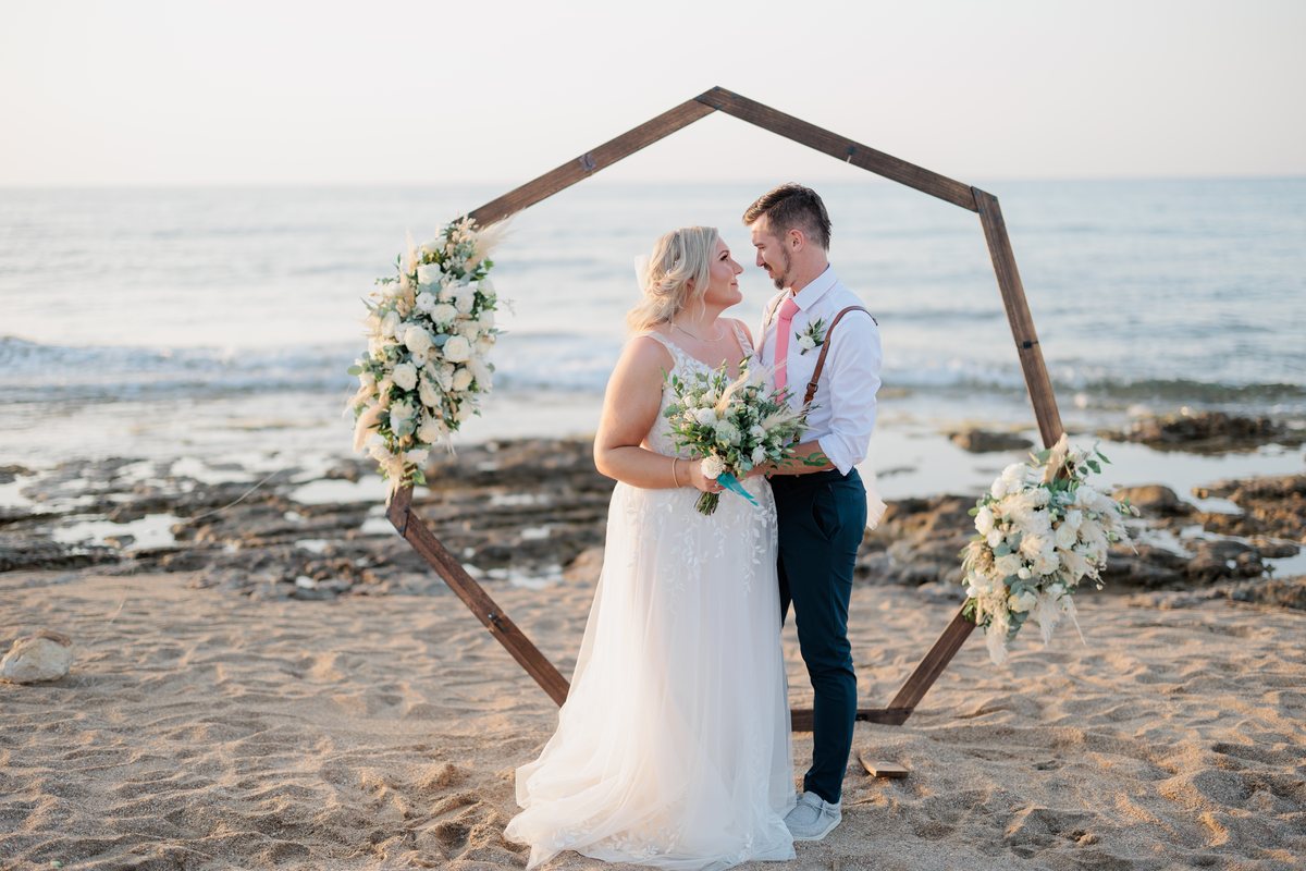 A groom and bride at a beach wedding, the groom in a white &Collar shirt